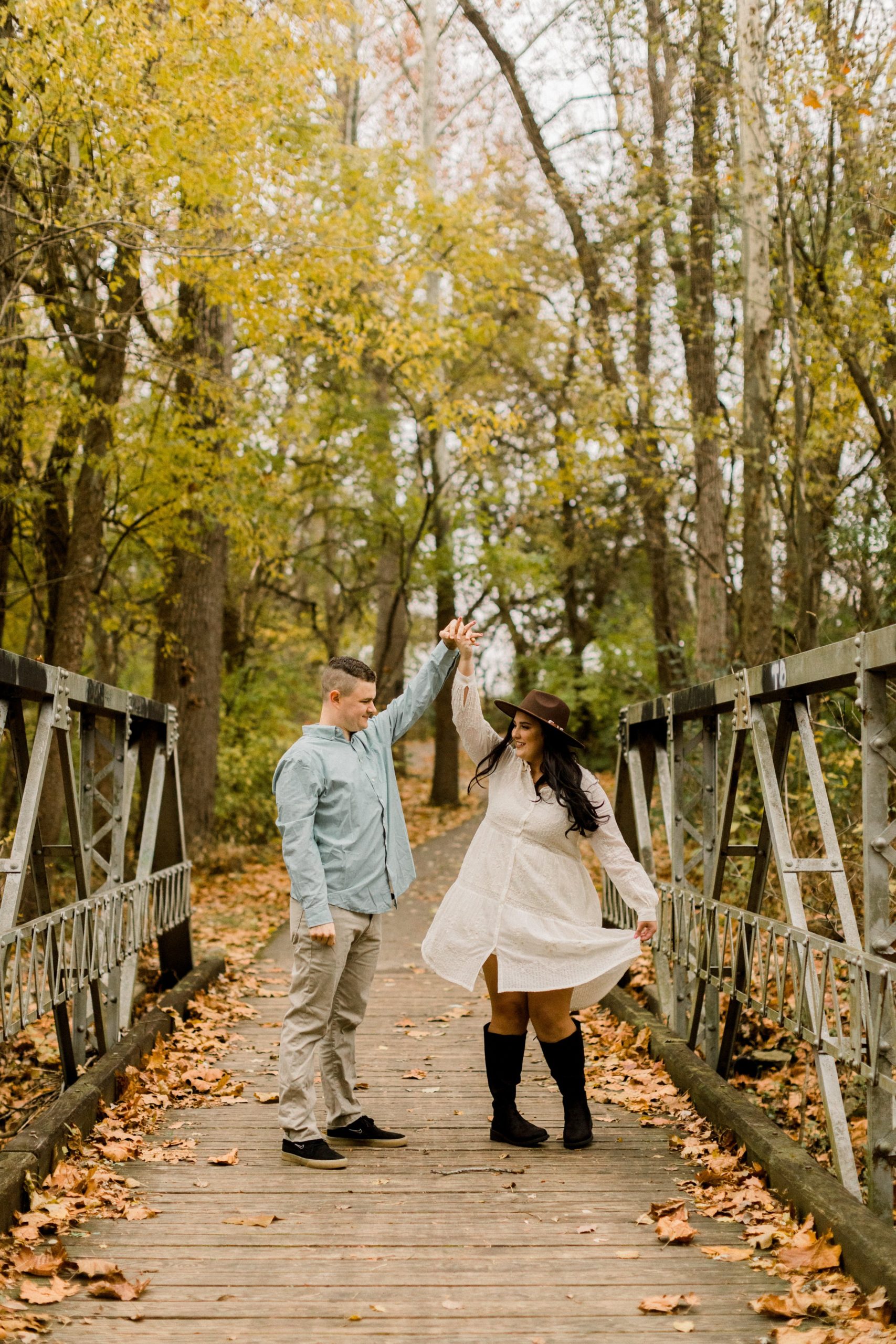 Couple dancing on a bride with fall leaves