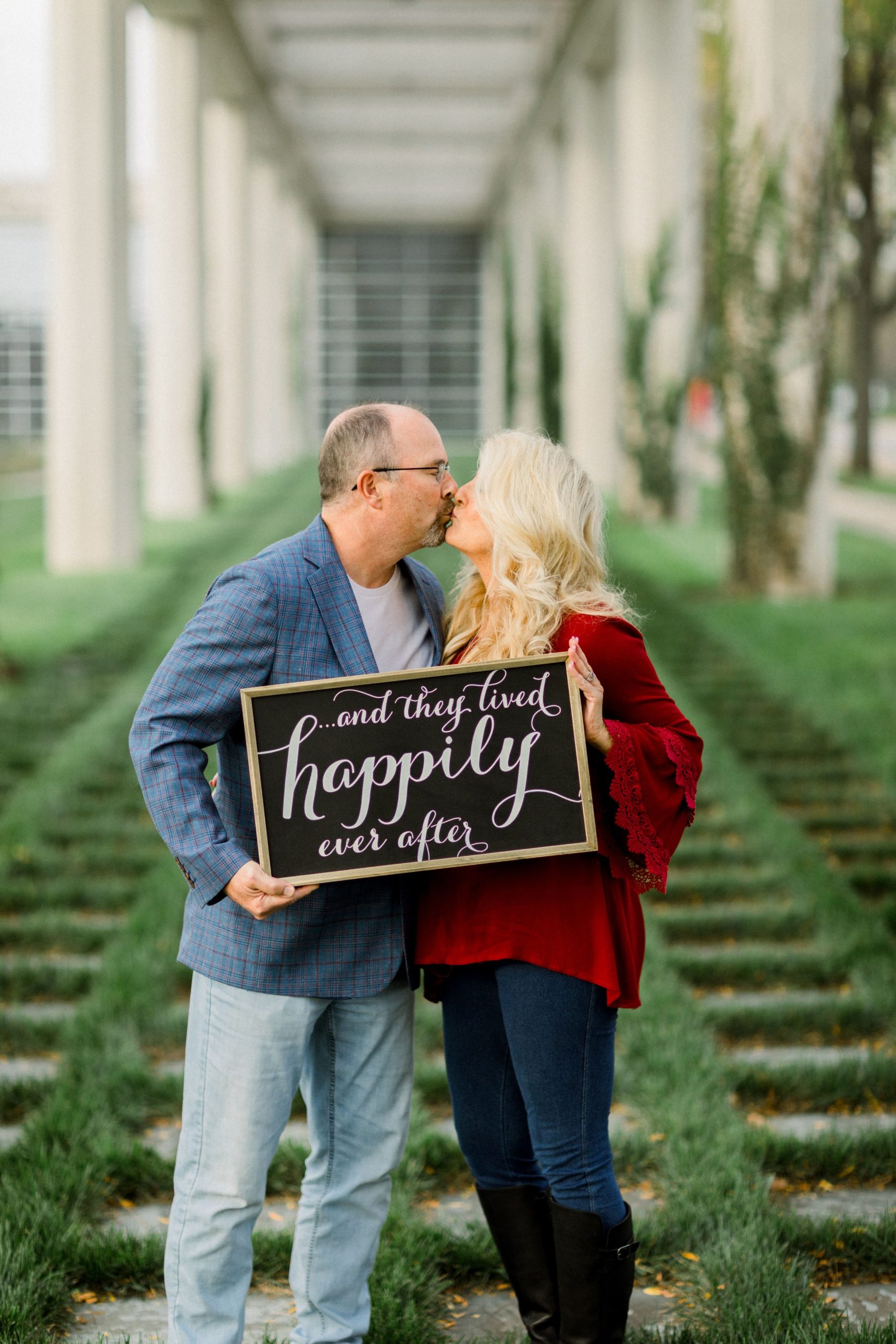couple celebrating their 30th anniversary with a custom sign and kiss