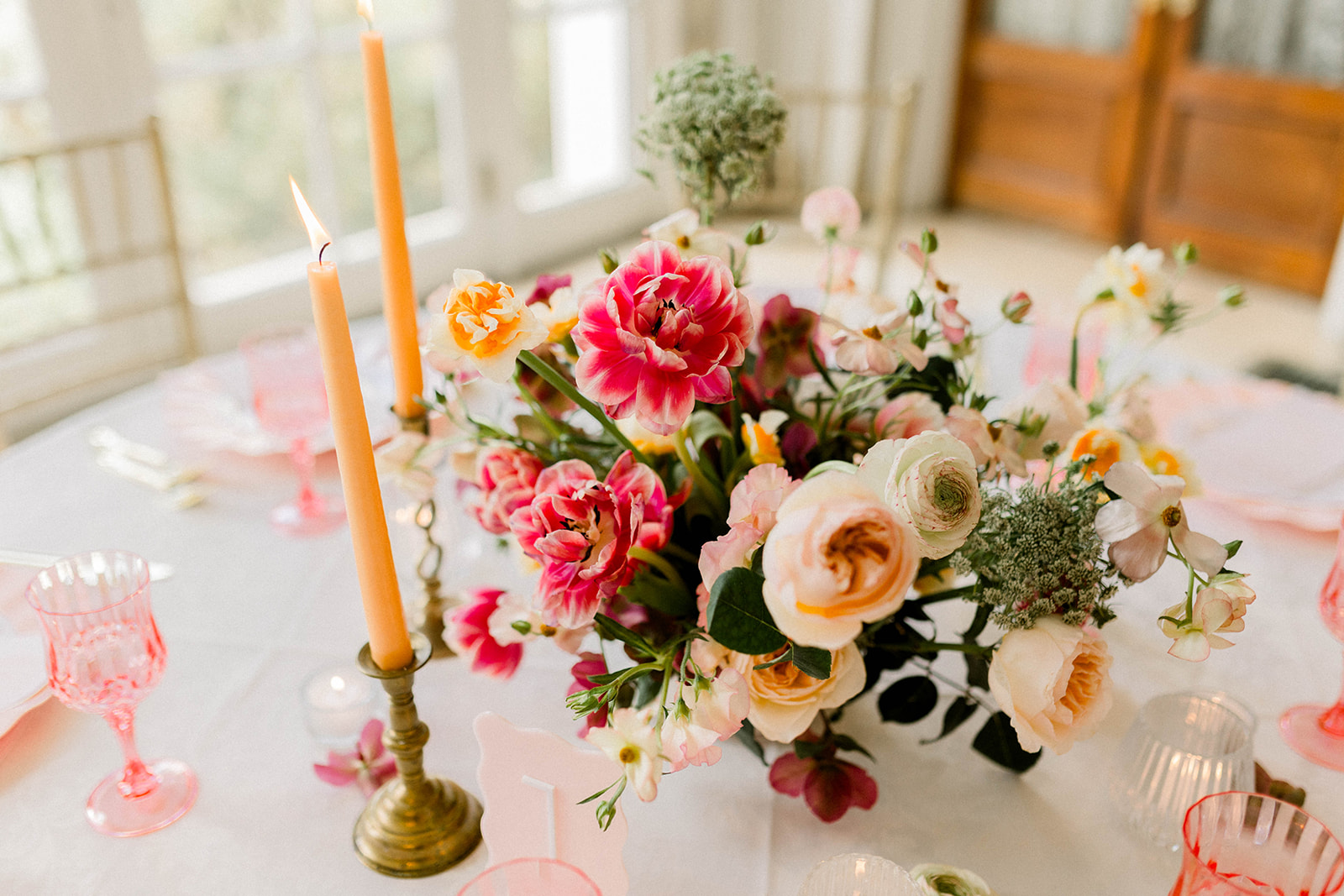 bright spring wedding table with candles and large windows behind it