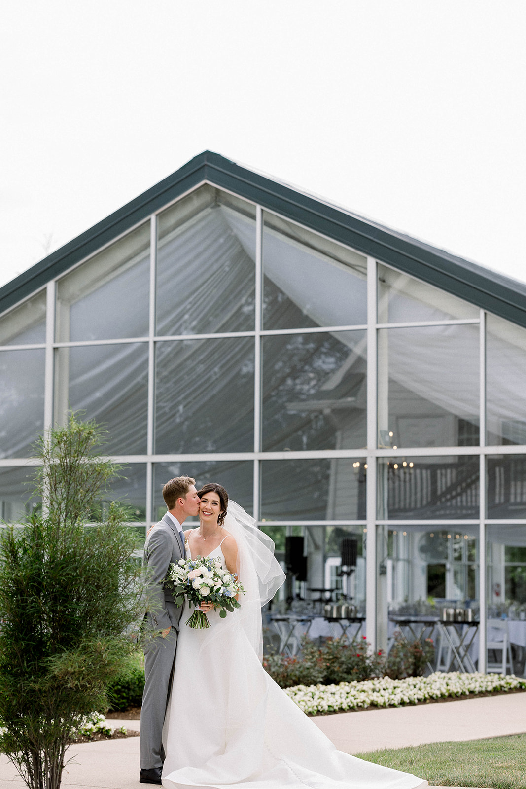 bride and groom portrait in front of Ritz Charles glass Garden Pavilion