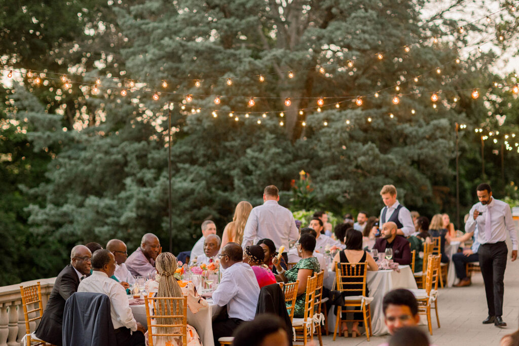 outdoor al fresco wedding reception with string lights and sunset light