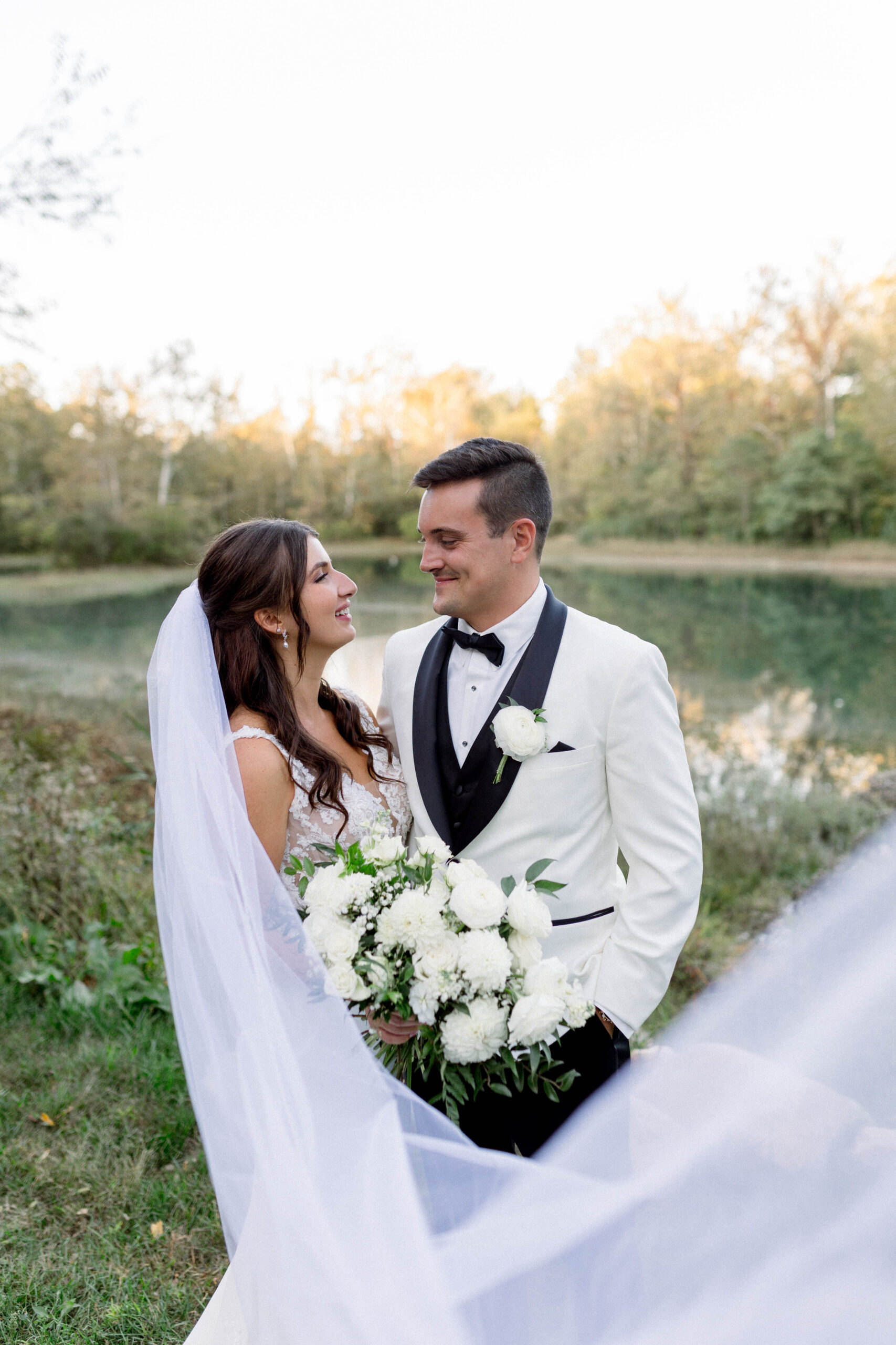 bride and groom at sunset in front of a lake