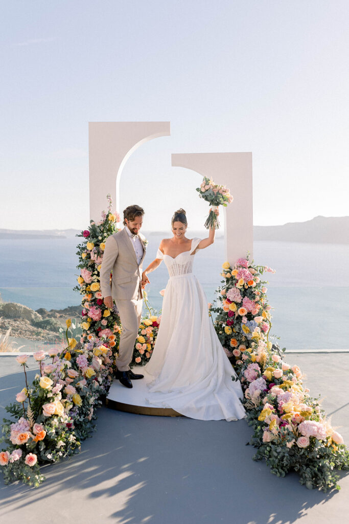 bride and groom ceremony in Santorini with Aegean Sea in the background - Best destination wedding cities